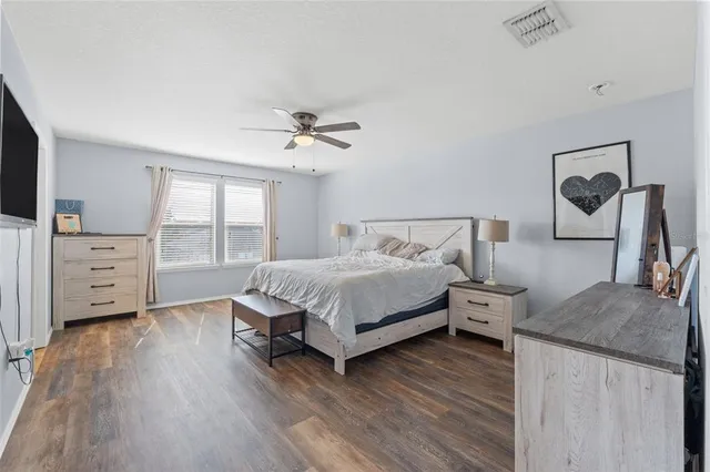 a bedroom with a bed and a flat tv screen on the dresser