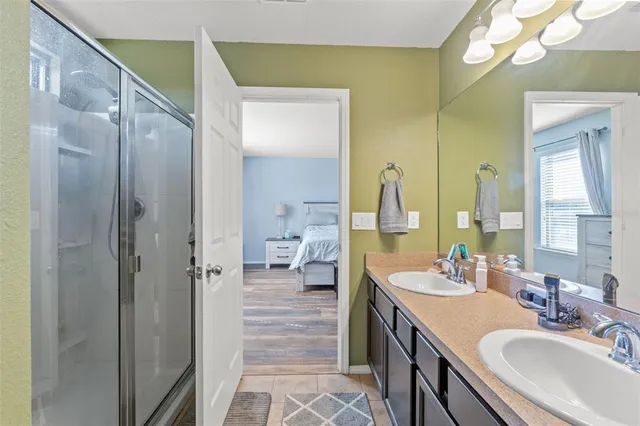 a en suite bathroom with a double vanity sink a mirror and a shower