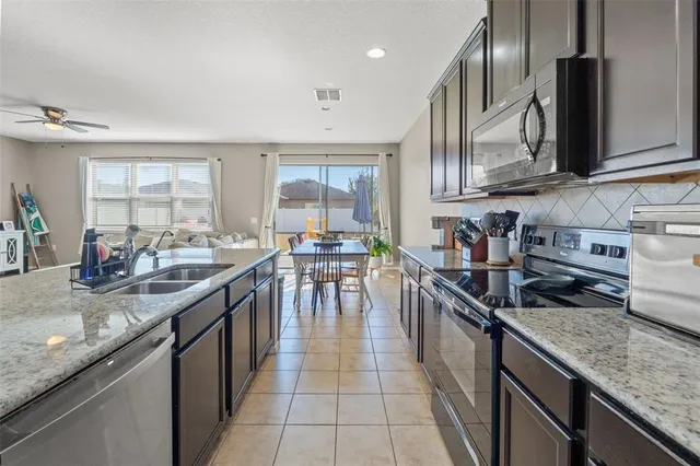 a kitchen with stainless steel appliances granite countertop sink stove top oven and cabinets