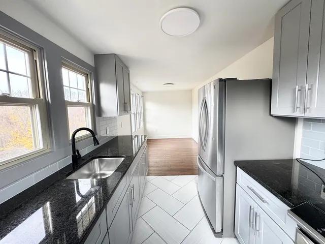 a kitchen with granite countertop a stove and a sink