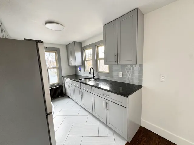 a kitchen with granite countertop white cabinets and white appliances