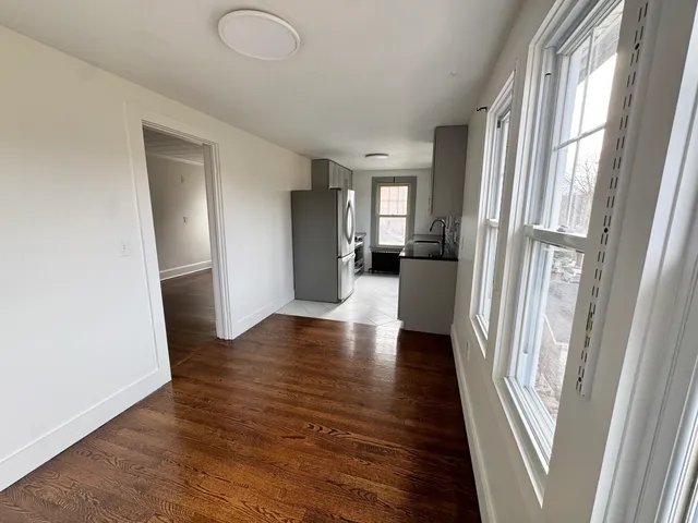 a view of a hallway with wooden floor and stairs