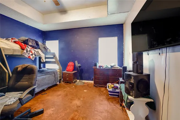 a living room with furniture a flat screen tv and a refrigerator