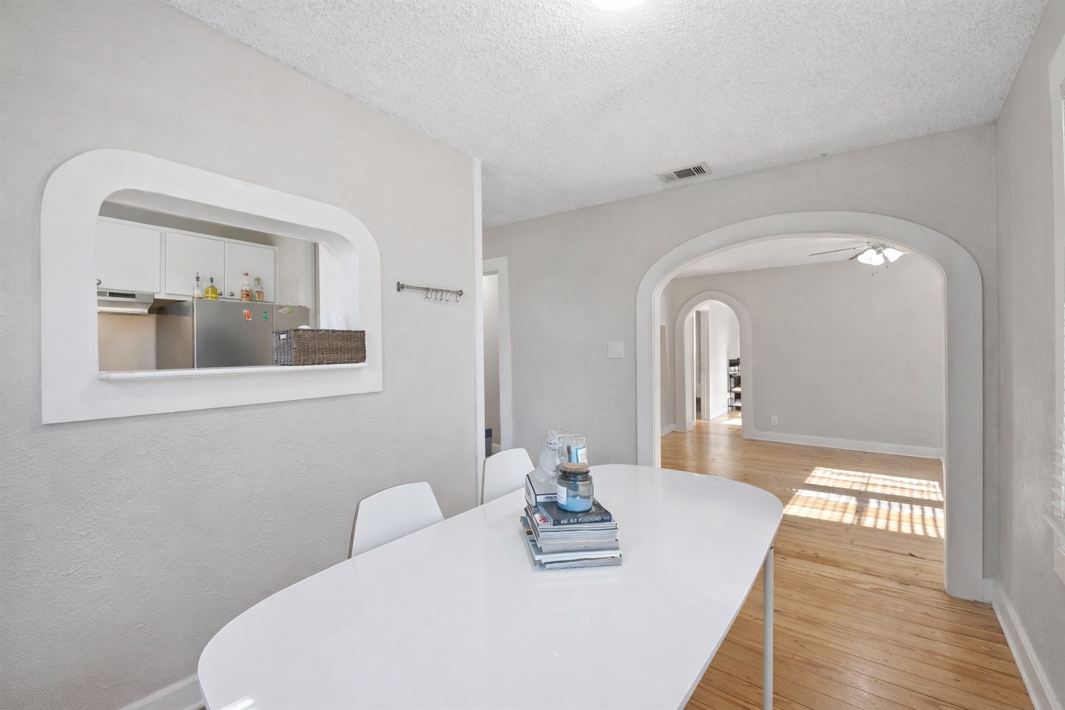 1202 East 29th Street, Unit A Austin, TX 78722 - Photo 11 of 22 Dining room featuring light wood-style floors, ceiling fan, and a textured ceiling