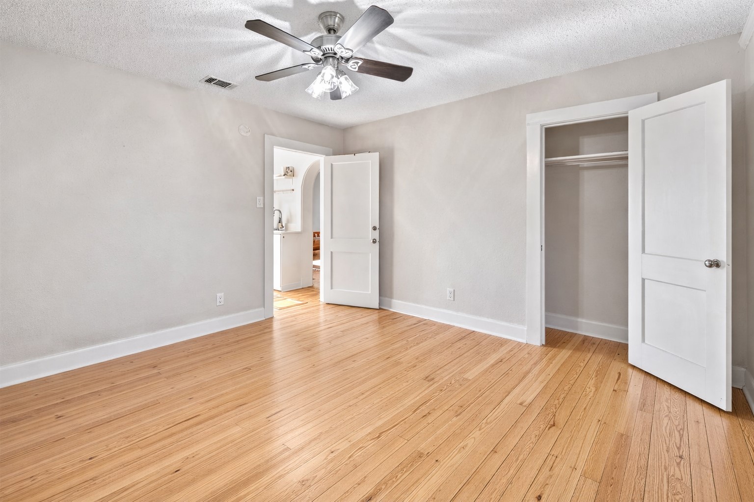 1202 East 29th Street, Unit A Austin, TX 78722 - Photo 14 of 22 Unfurnished bedroom with light wood-style floors, a textured ceiling, ceiling fan, and a closet