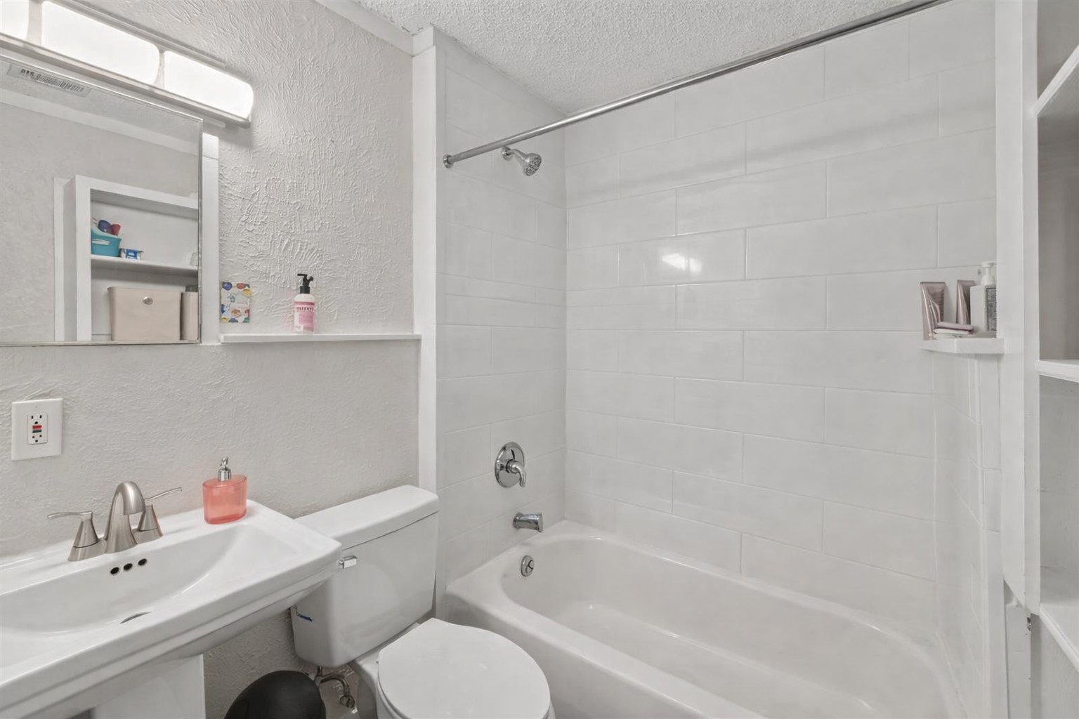 1202 East 29th Street, Unit A Austin, TX 78722 - Photo 18 of 22 Bathroom featuring a textured wall, a textured ceiling, and washtub / shower combination