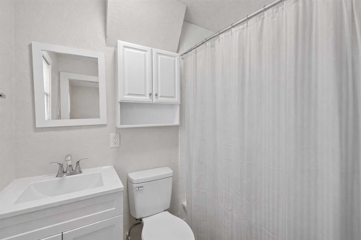 1202 East 29th Street, Unit A Austin, TX 78722 - Photo 21 of 22 Bathroom featuring vanity, a shower with shower curtain, a textured wall, and a textured ceiling