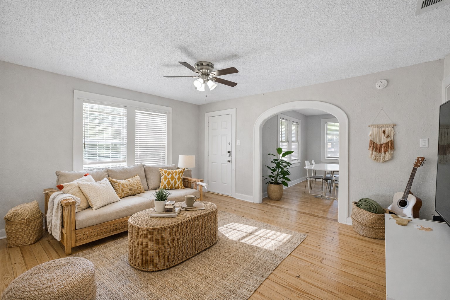 1202 East 29th Street, Unit A Austin, TX 78722 - Photo 4 of 22 Living area featuring light wood finished floors, arched walkways, a ceiling fan, and a textured ceiling