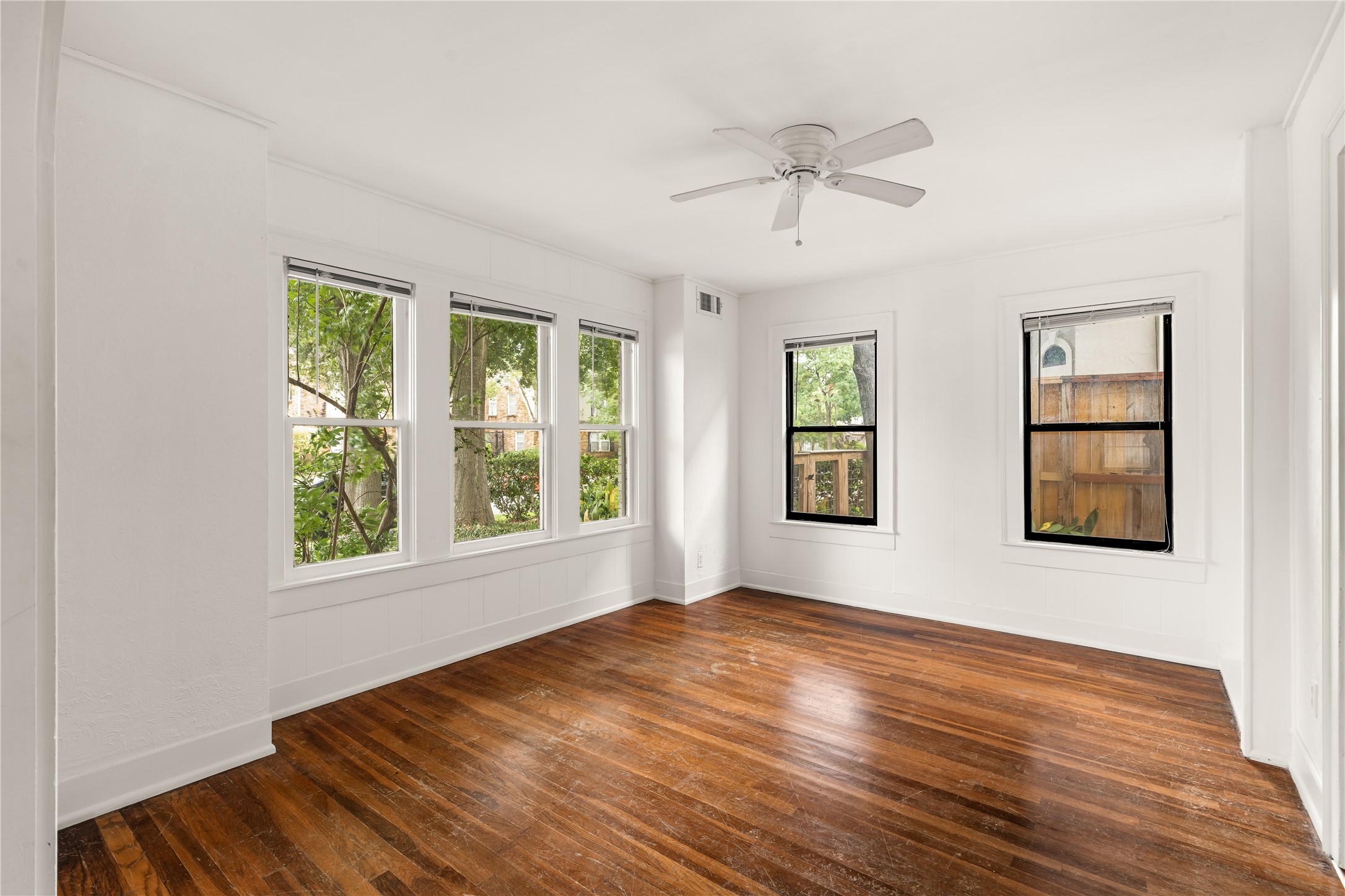 2202 West Main Street Houston, TX 77098 - Photo 7 of 32 a view of an empty room with wooden floor and a window