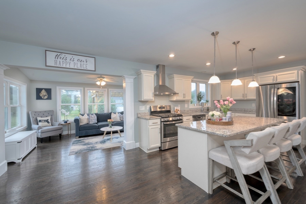 4 Sycamore Lane Bridgewater, MA 02324 - Photo 13 of 42 a kitchen with stainless steel appliances kitchen island granite countertop a stove a refrigerator a kitchen island a dining table and chairs with wooden floor