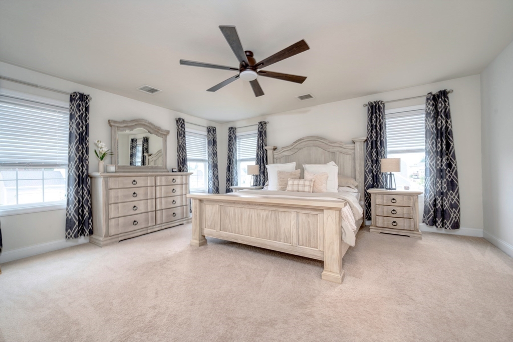 4 Sycamore Lane Bridgewater, MA 02324 - Photo 23 of 42 a bedroom with a large bed and a chandelier