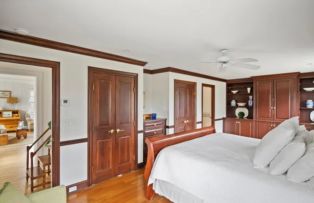 a bedroom with a bed wooden floor and window
