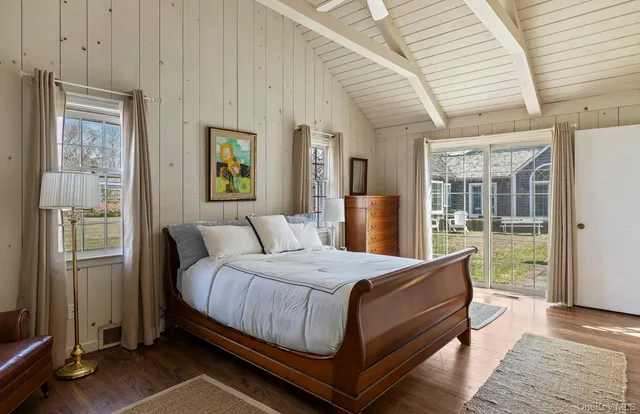 a bedroom with a bed wooden floor and window