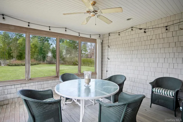 a view of a dining room with furniture a chandelier and large windows