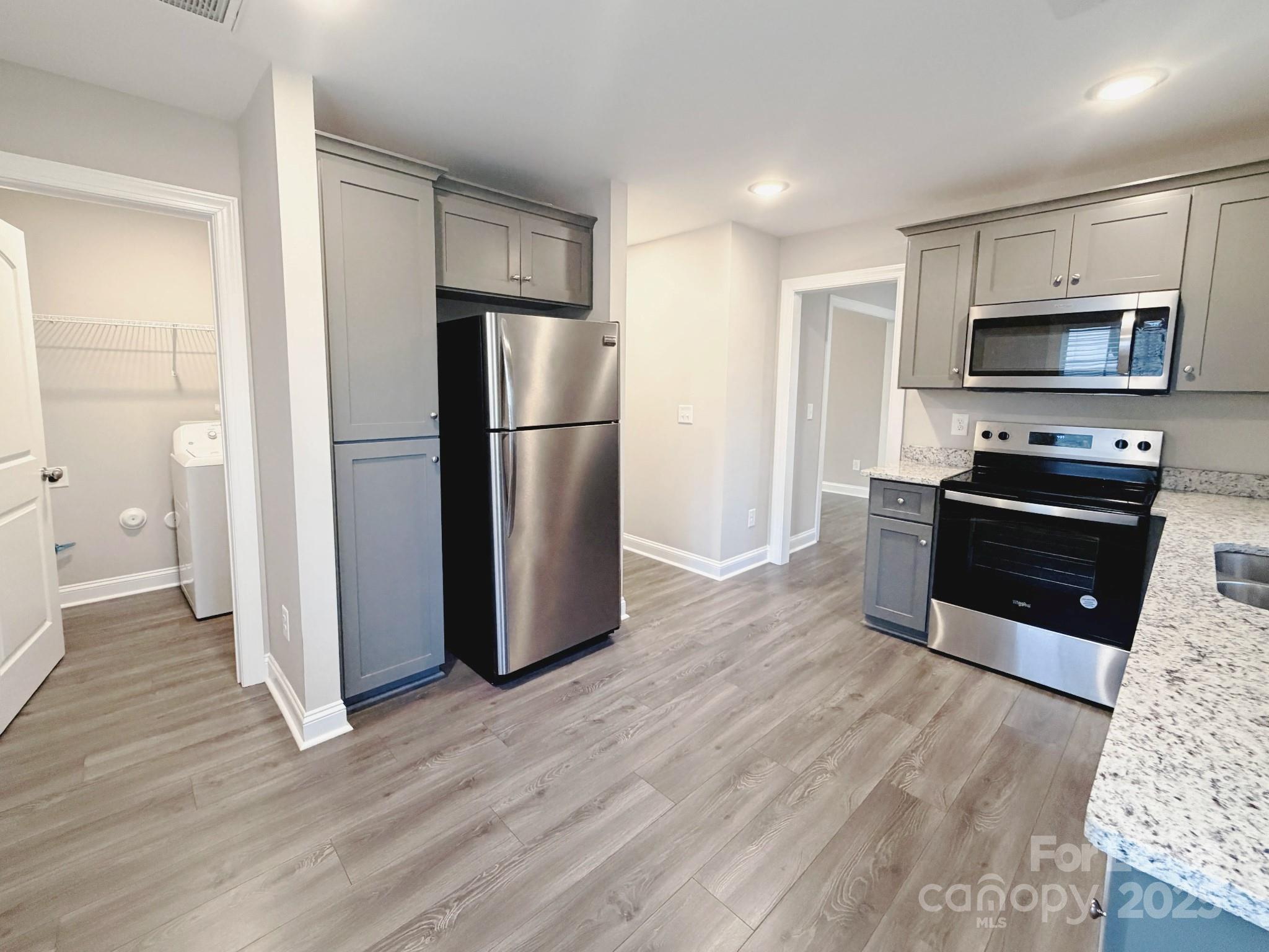 921 Pineridge Street Southeast Concord, NC 28025 - Photo 4 of 13 a kitchen with stainless steel appliances a refrigerator stove and microwave