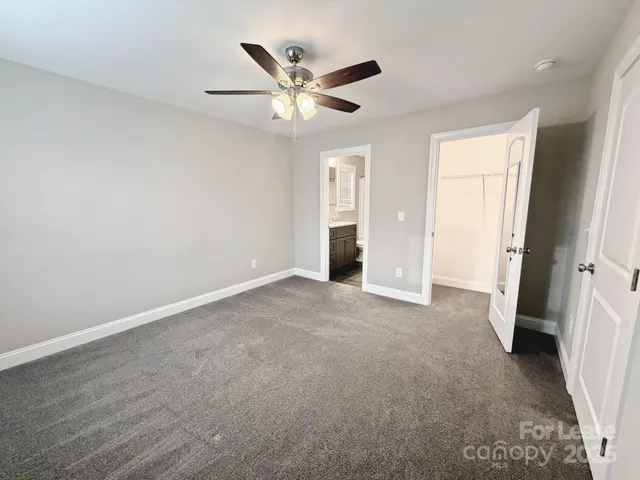 an empty room with closet and a ceiling fan