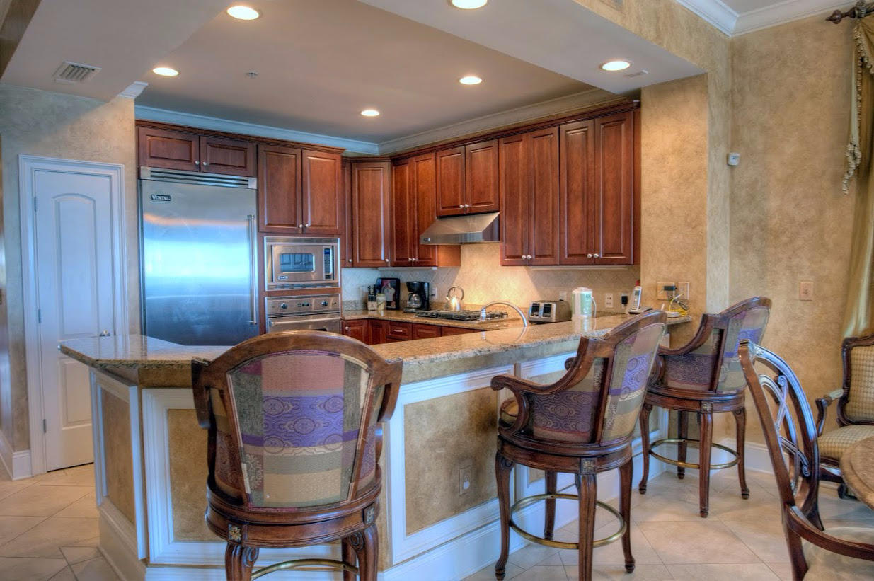 2421 West County Highway 30A, Unit C201 Santa Rosa Beach, FL 32459 - Photo 12 of 50 a kitchen with kitchen island a dining table chairs cabinets and stainless steel appliances
