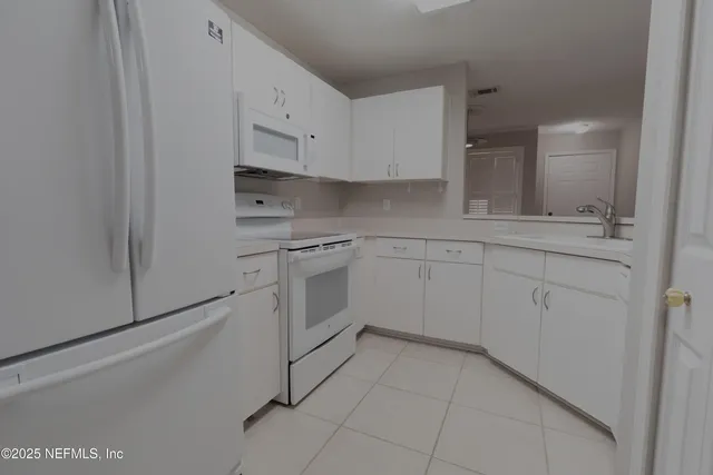 a kitchen with white cabinets stainless steel appliances and sink