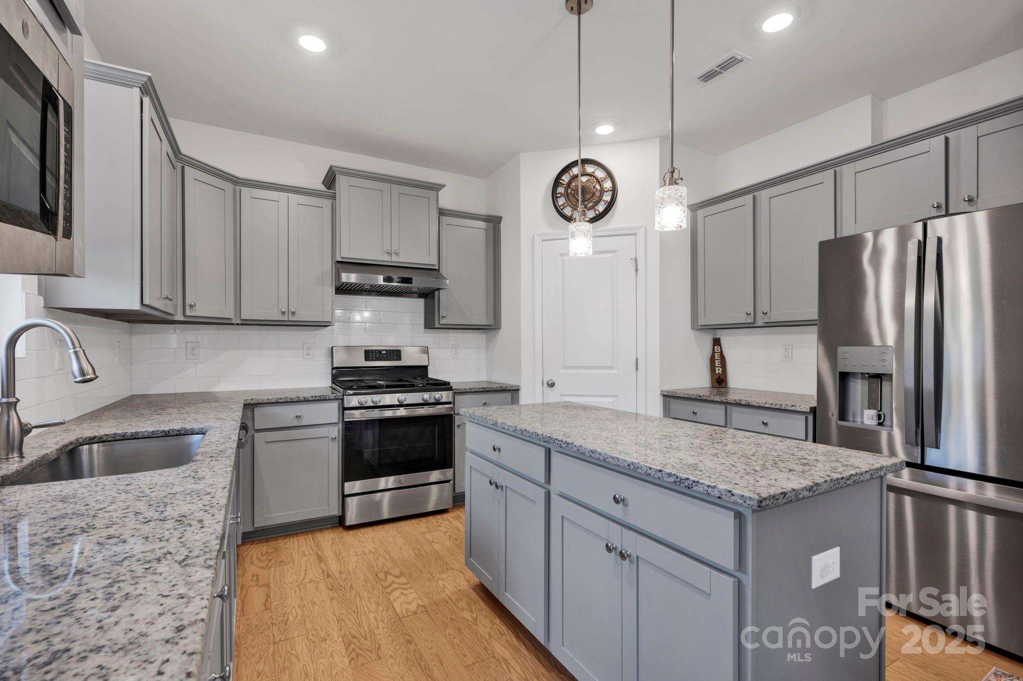 2712 Trinity Street Monroe, NC 28110 - Photo 8 of 48 a kitchen with stainless steel appliances granite countertop a stove a sink and a refrigerator
