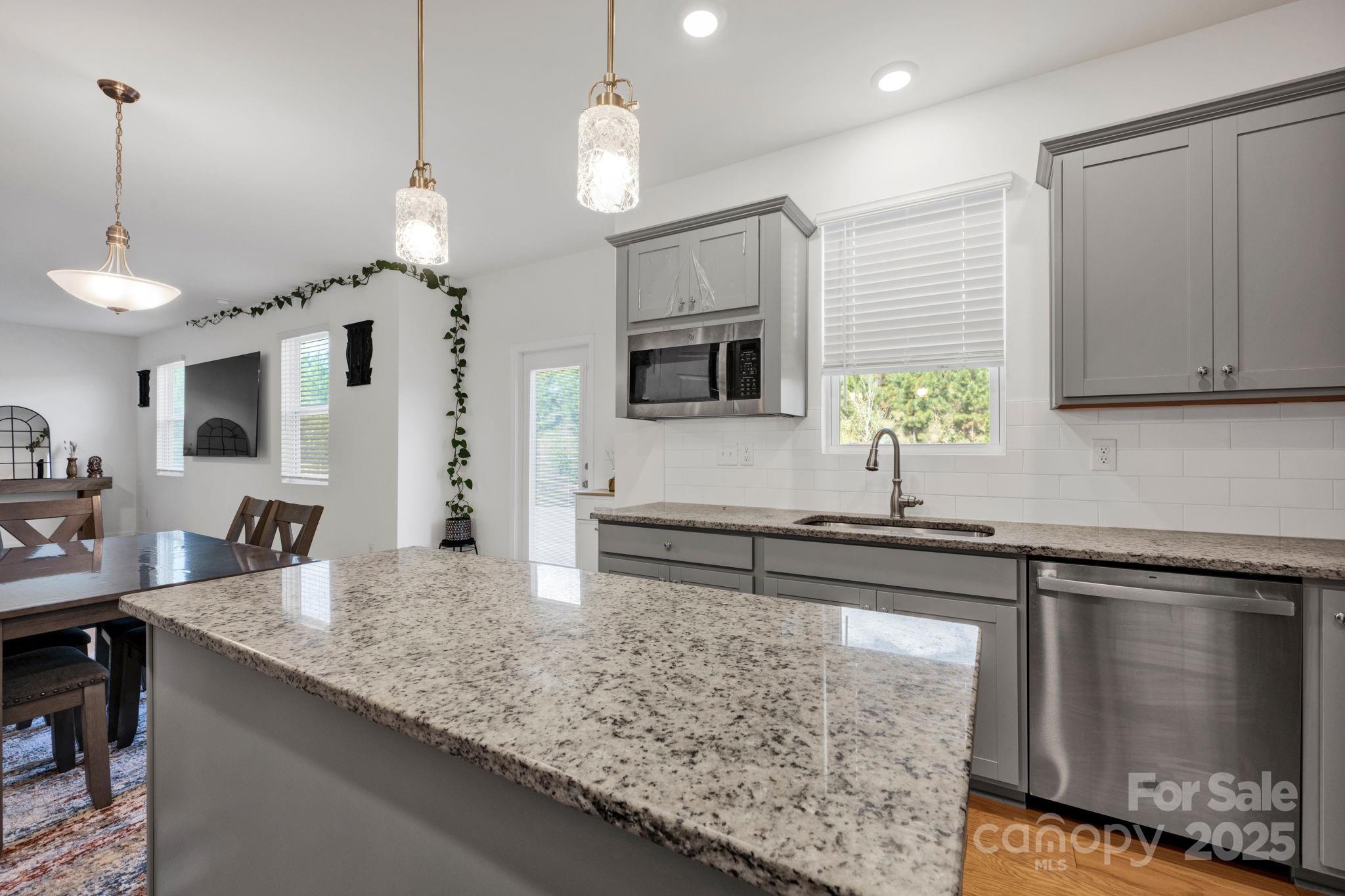 2712 Trinity Street Monroe, NC 28110 - Photo 10 of 48 a kitchen with kitchen island granite countertop a sink a counter top space appliances and cabinets