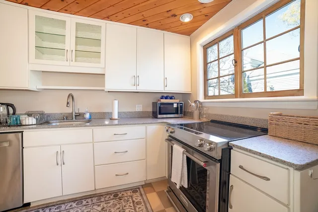 a kitchen with cabinets appliances a sink and a window