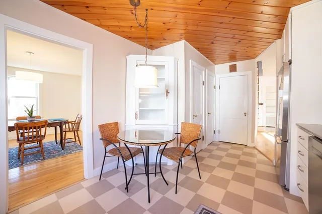 a kitchen with a dining table chairs and cabinets