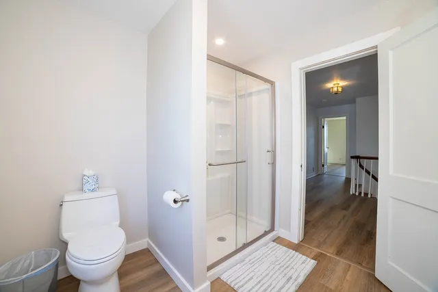 a bathroom with a granite countertop sink toilet and a window