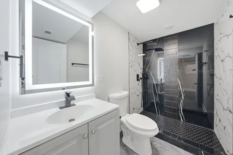 a bathroom with a sink toilet and shower