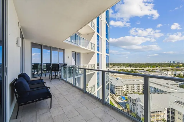 a living room with furniture kitchen view and a large window
