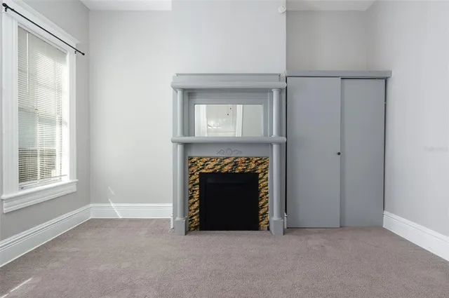 an empty room with a fireplace and a window