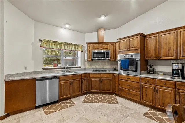 a kitchen with stainless steel appliances granite countertop a sink and cabinets