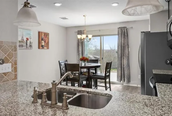a kitchen with stainless steel appliances granite countertop a sink a stove and a refrigerator