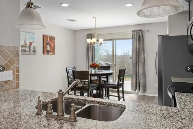 a kitchen with stainless steel appliances granite countertop a sink a stove and a refrigerator