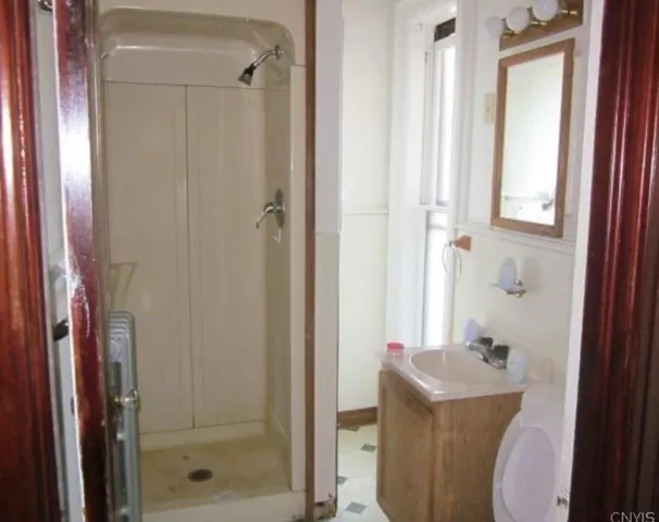a bathroom with a shower a toilet and a sink