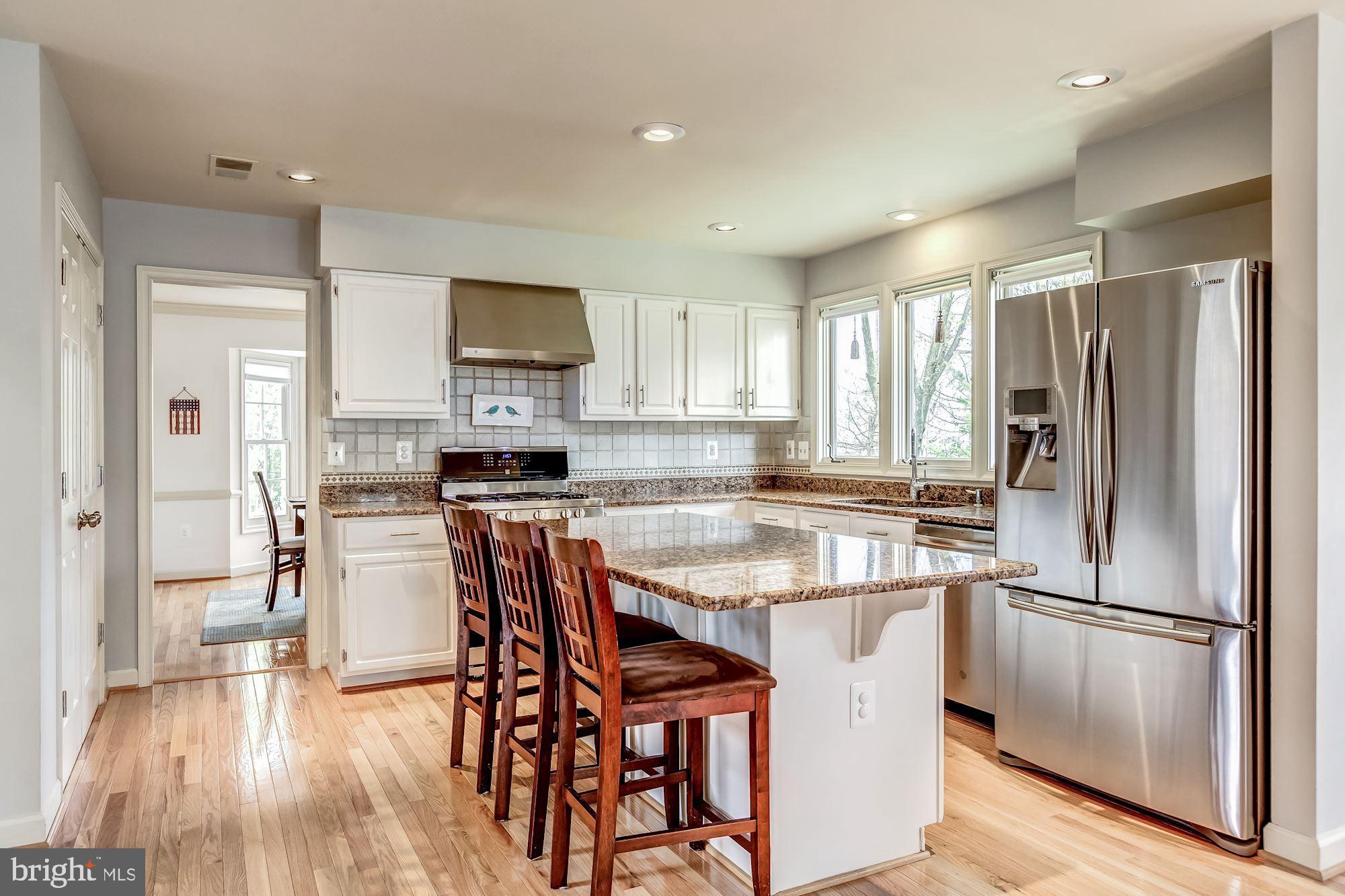 6402 Springhouse Circle Clifton, VA 20124 - Photo 21 of 43 a kitchen with stainless steel appliances granite countertop a refrigerator a stove a sink a dining table and chairs