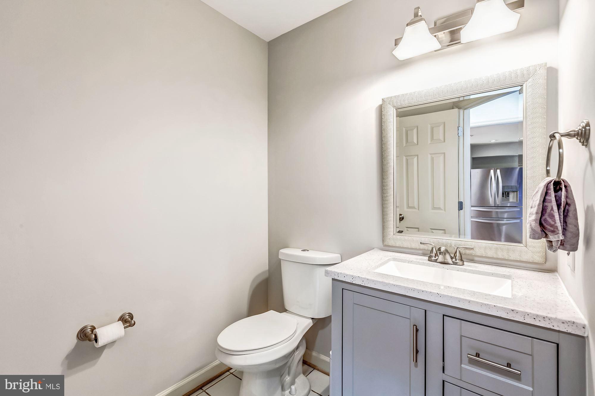 6402 Springhouse Circle Clifton, VA 20124 - Photo 6 of 43 a bathroom with a granite countertop toilet a sink and a mirror