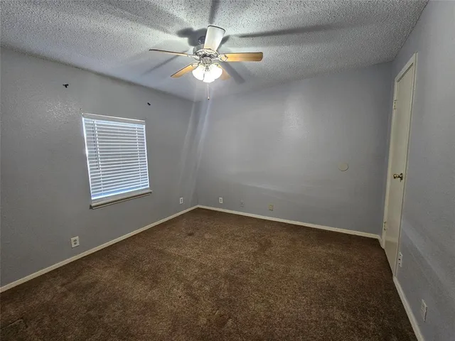 an empty room with a chandelier fan