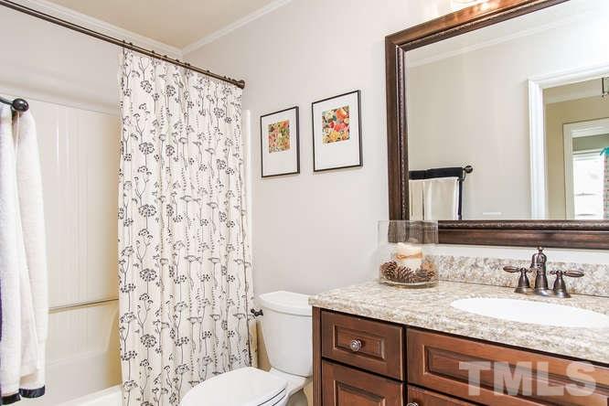 1100 Toppe Ridge Court Raleigh, NC 27615 - Photo 14 of 22 a bathroom with a granite countertop sink a toilet and a mirror