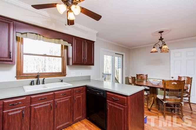 1100 Toppe Ridge Court Raleigh, NC 27615 - Photo 7 of 22 a kitchen with a sink chandelier and a stove