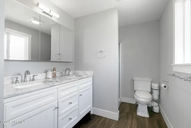 a bathroom with a granite countertop toilet sink and mirror