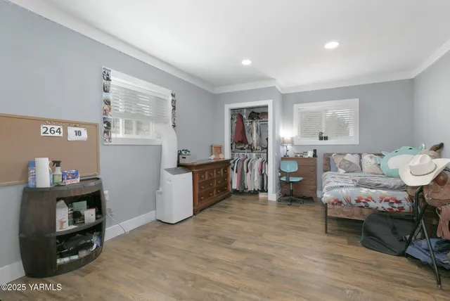 a bedroom with furniture and a wooden floor