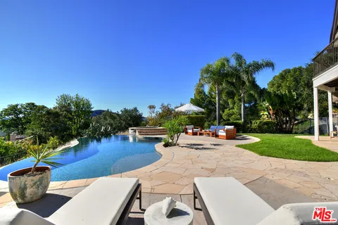 a view of a house with pool and sitting area