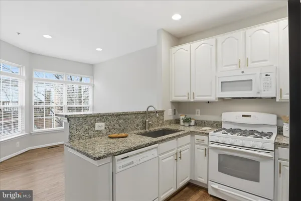 a kitchen with granite countertop a sink and cabinets