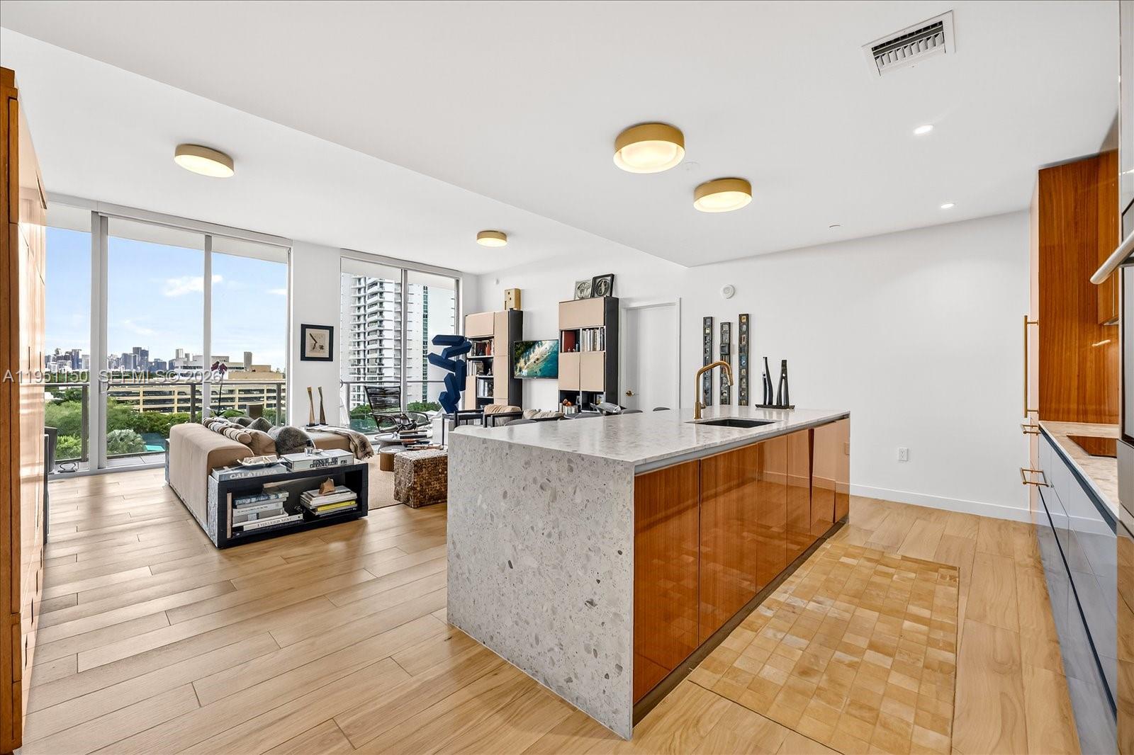 2678 Tigertail Avenue, Unit 604 Miami, FL 33133 - Photo 3 of 25 a living room with kitchen island furniture and a wooden floor