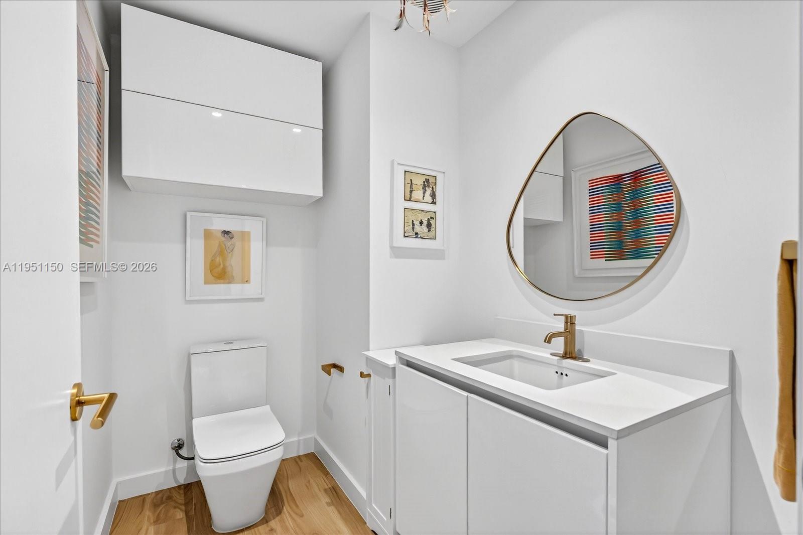 2678 Tigertail Avenue, Unit 604 Miami, FL 33133 - Photo 6 of 25 a bathroom with a sink toilet and a mirror