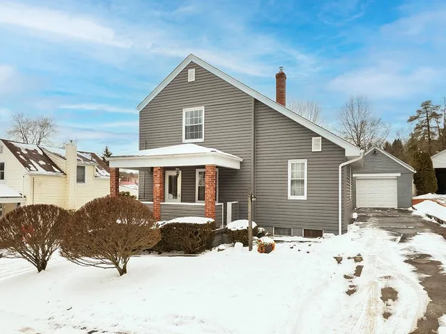 a front view of a house with a yard covered in snow