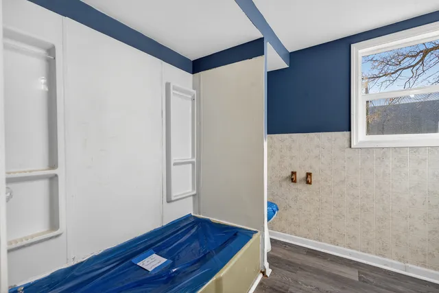 a view of an empty room with wooden floor and closet