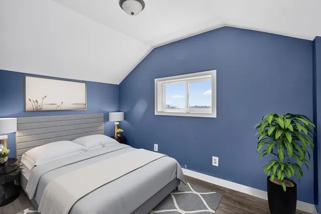 a bedroom with a bed and a potted plant