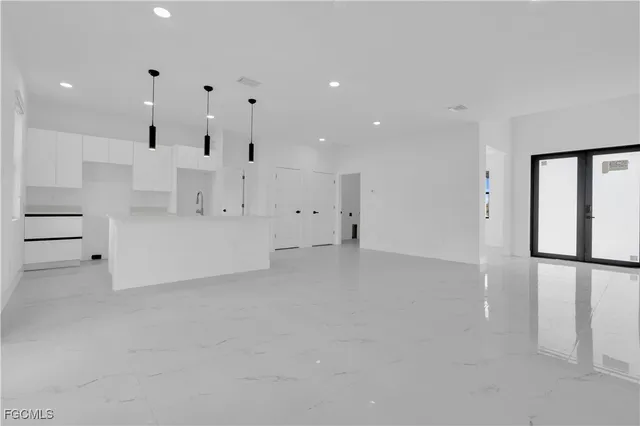 an empty room with windows and cabinet