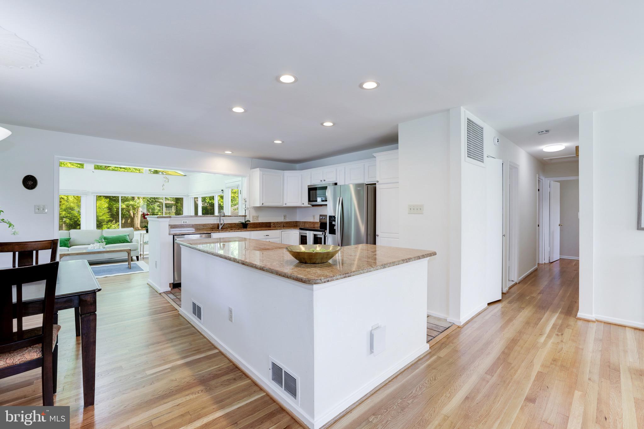 8305 Fort Hunt Road Alexandria, VA 22308 - Photo 16 of 74 a kitchen with stainless steel appliances kitchen island granite countertop a sink and a refrigerator